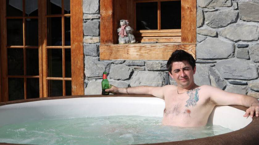 Luxury Chalets Morzine hot tub outdoor man with beer relaxing