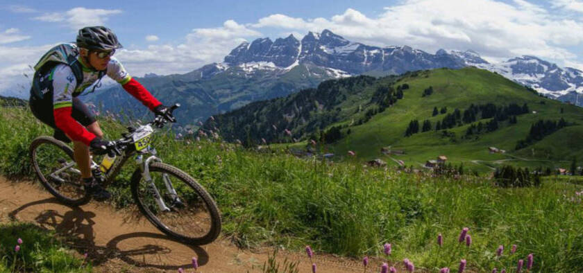 morzine summer events man riding bike with mountain scenery